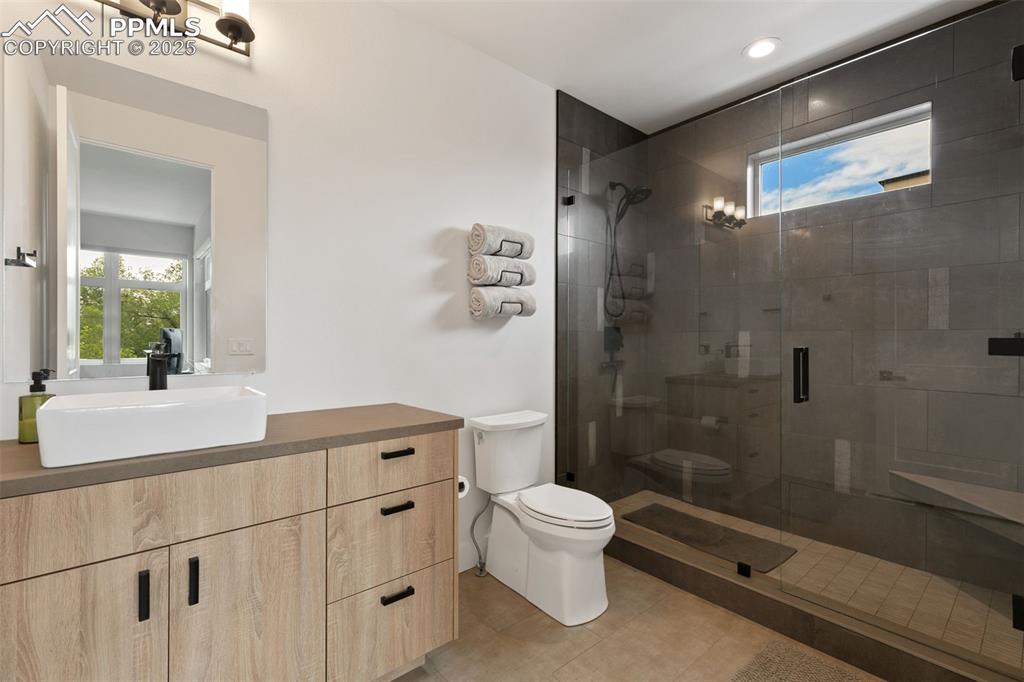 50 Sommerlyn Road Colorado Springs, CO 80906 - Photo 28 of 39 a bathroom with a sink a toilet a mirror and shower
