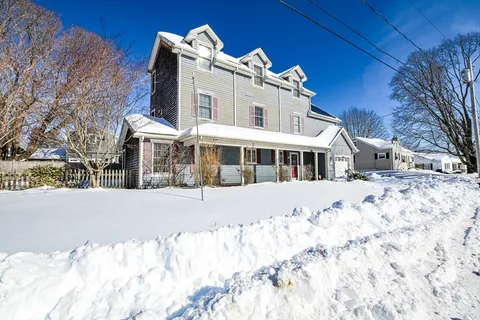 a front view of a house with a yard covered in snow