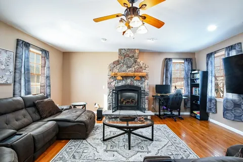 a living room with furniture a flat screen tv and a fireplace