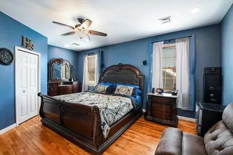 a bedroom with a bed a dresser and flat screen tv