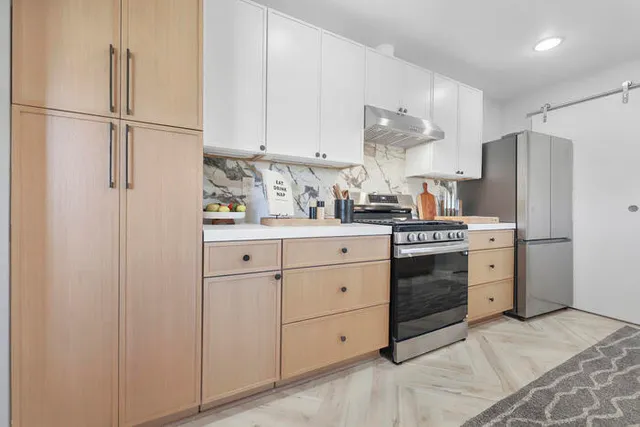 a kitchen with white cabinets and stainless steel appliances