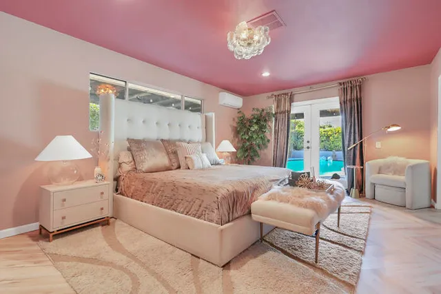 a spacious bedroom with a bed and a chandelier