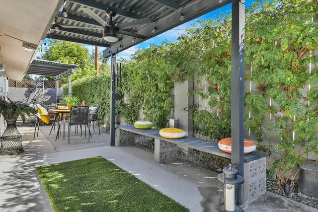 a view of a patio with a table chairs and a small yard
