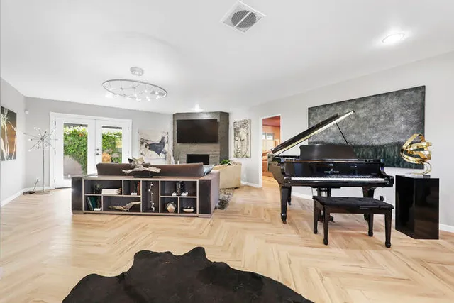 a living room with furniture and a flat screen tv with kitchen view