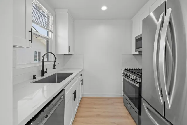a kitchen with stainless steel appliances granite countertop a refrigerator and a sink
