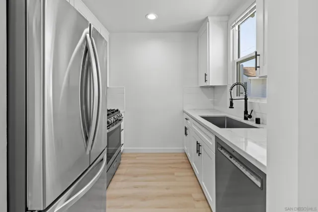 a kitchen with stainless steel appliances granite countertop a refrigerator and a sink