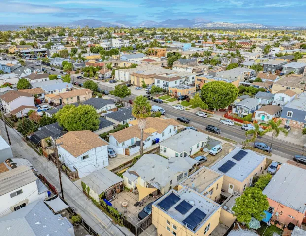 an aerial view of a city with lots of residential buildings and parking space