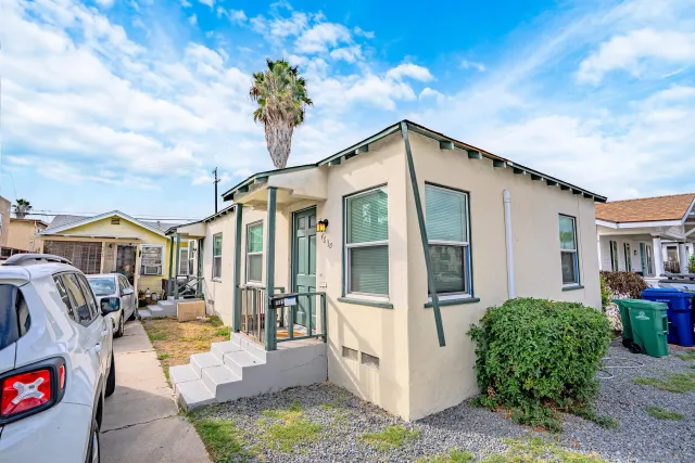 a view of a house with backyard and sitting area