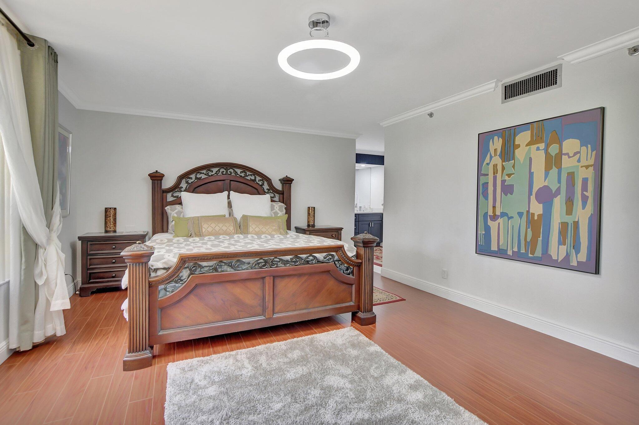 7194 Promenade Drive, Unit 102 Boca Raton, FL 33433 - Photo 26 of 56 a bedroom with a bed and a painting on the wall