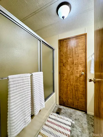 a view of a patio with table and chairs under an umbrella with wooden fence