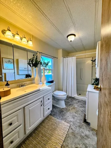 a bathroom with a granite countertop toilet sink and mirror