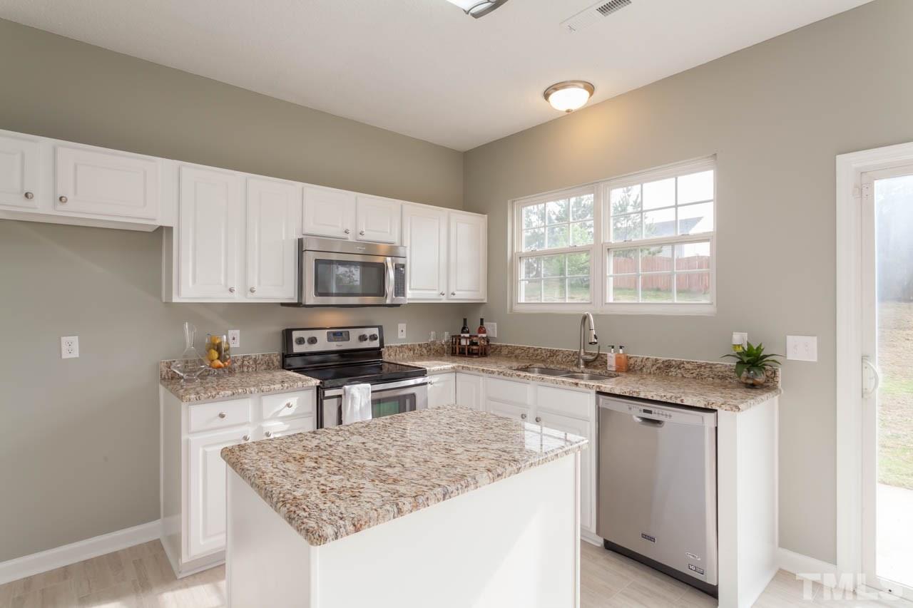 2929 Ranburne Drive Raleigh, NC 27610 - Photo 3 of 22 a kitchen with stainless steel appliances granite countertop a sink stove and refrigerator