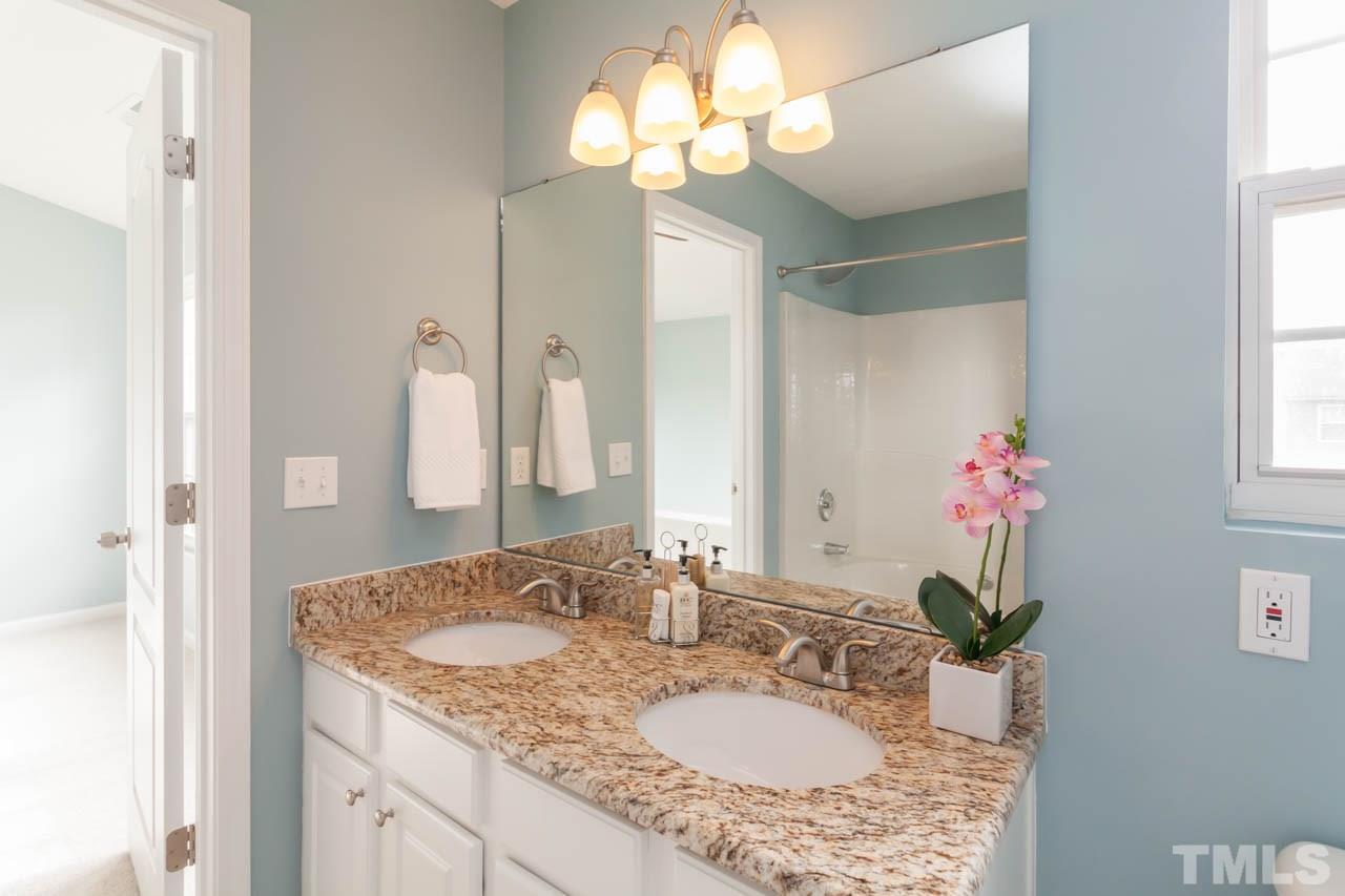 2929 Ranburne Drive Raleigh, NC 27610 - Photo 4 of 22 a bathroom with a granite countertop sink a large mirror and a shower