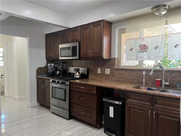 a kitchen with stainless steel appliances granite countertop a sink stove and microwave