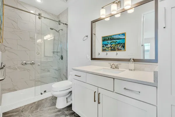 a bathroom with a double vanity sink toilet and shower