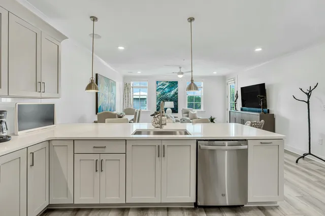 a kitchen with kitchen island granite countertop a sink a counter space appliances and cabinets