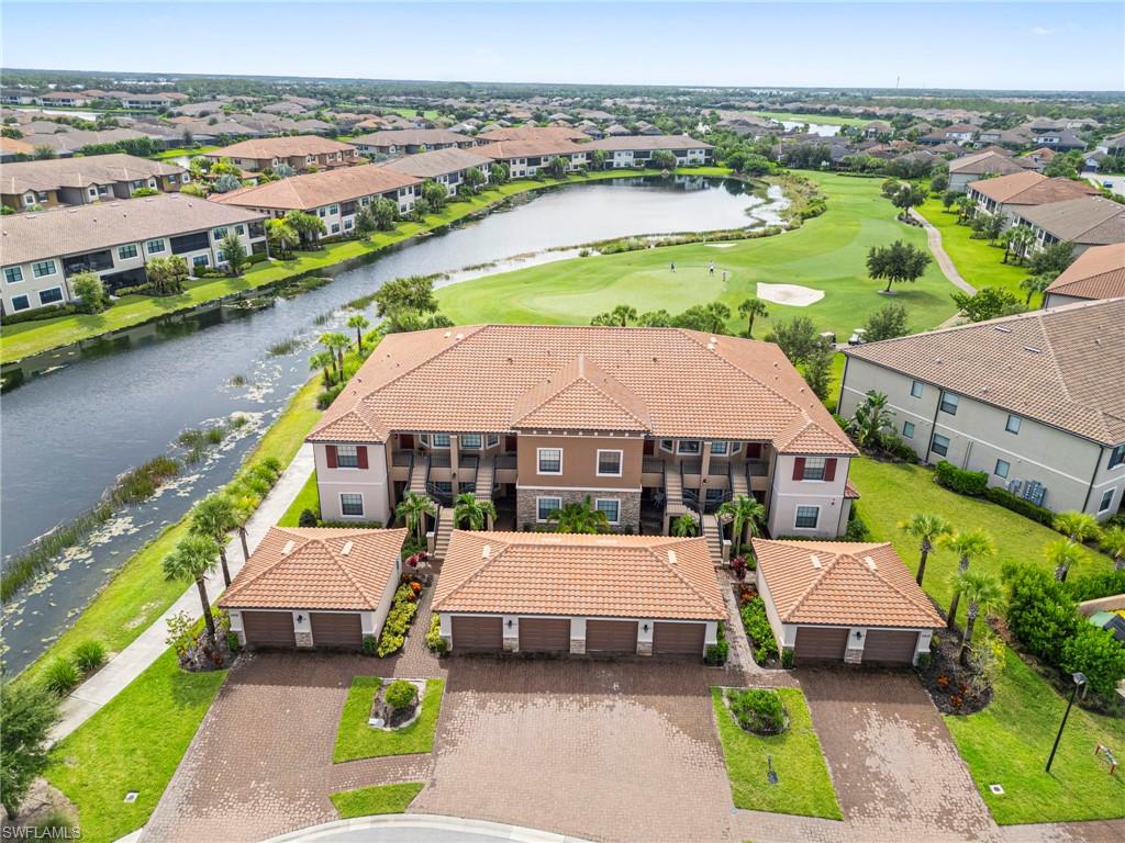 9402 Pocida Court, Unit 202 Naples, FL 34119 - Photo 1 of 31 Aerial perspective of suburban area with a nearby body of water and a golf course