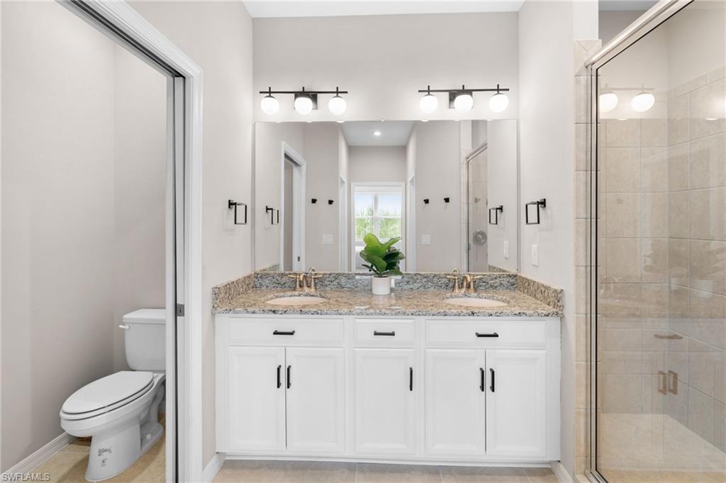 9402 Pocida Court, Unit 202 Naples, FL 34119 - Photo 21 of 31 Full bath with double vanity, a stall shower, and light tile patterned floors