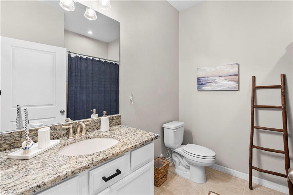 9402 Pocida Court, Unit 202 Naples, FL 34119 - Photo 24 of 31 Bathroom with a shower with curtain, light tile patterned floors, and vanity