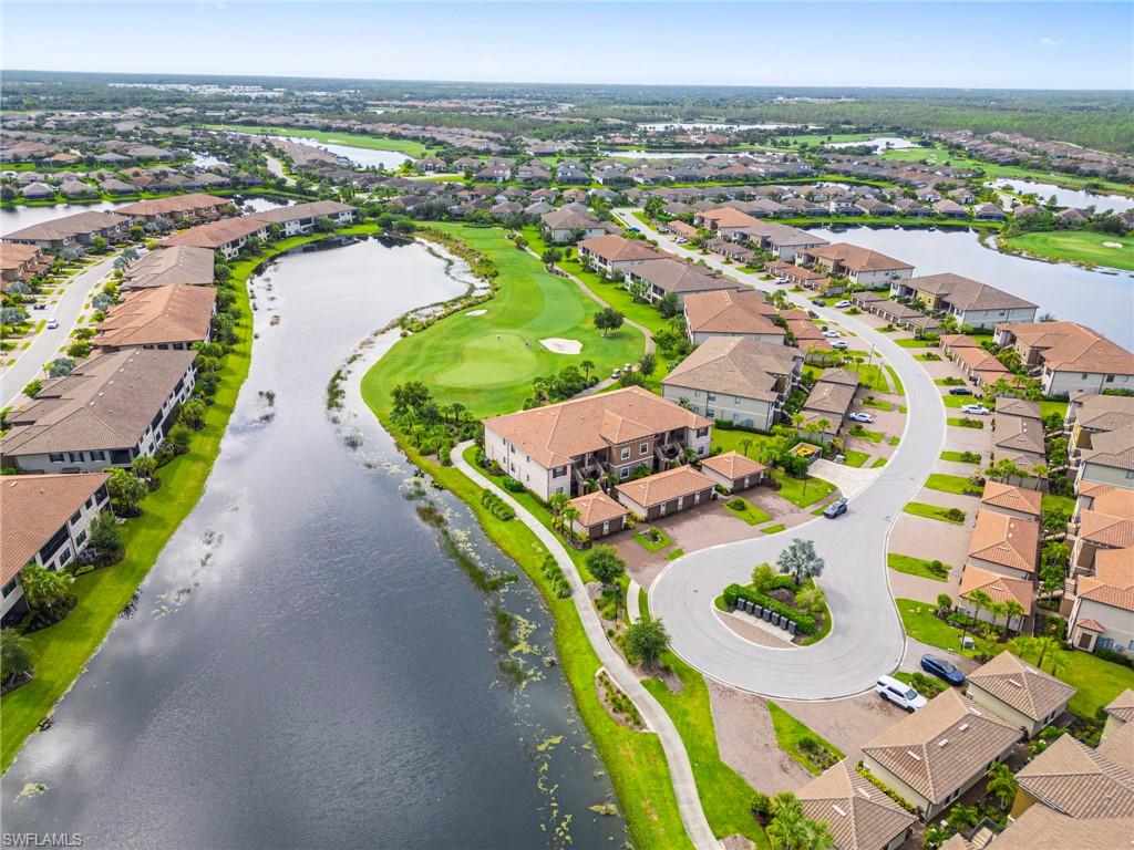 9402 Pocida Court, Unit 202 Naples, FL 34119 - Photo 4 of 31 Aerial perspective of suburban area with a large body of water and a golf course