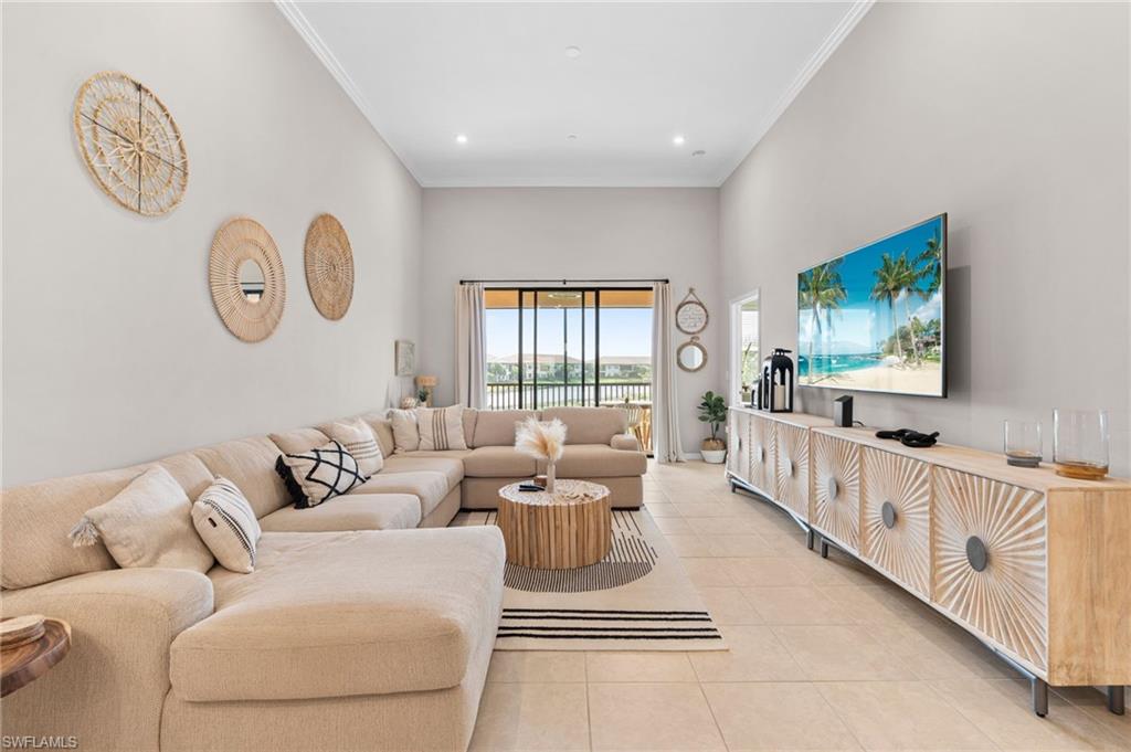 9402 Pocida Court, Unit 202 Naples, FL 34119 - Photo 6 of 31 Living room with crown molding, a towering ceiling, light tile patterned floors, and recessed lighting
