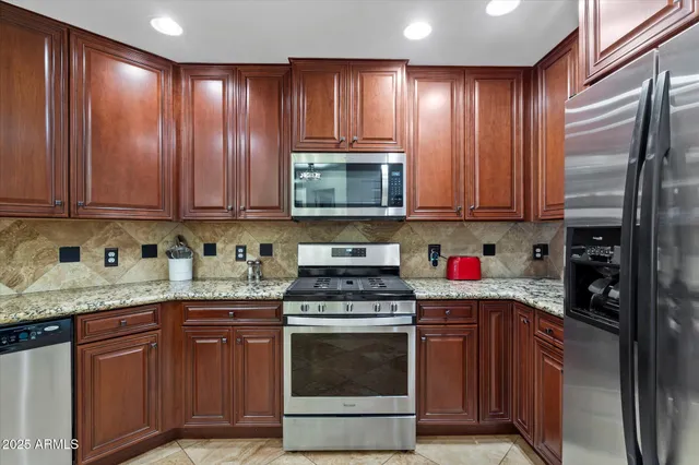 a kitchen with granite countertop wooden cabinets and a stove top oven