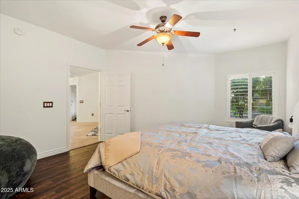 a bedroom with a bed chandelier and a window