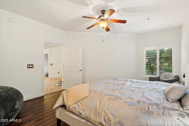 a bedroom with a bed chandelier and a window