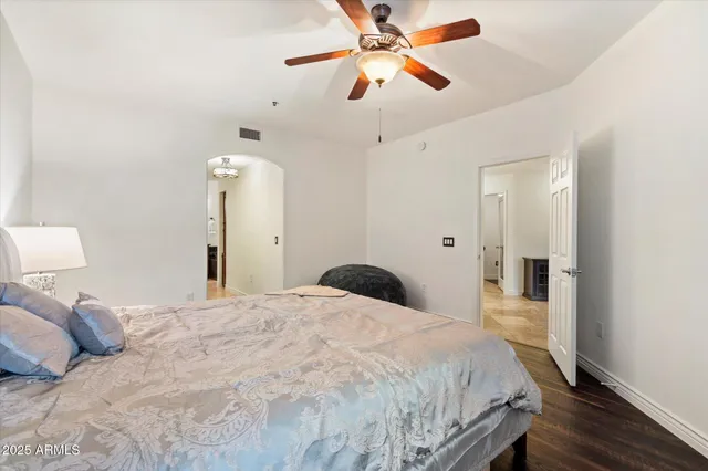 a bedroom with a large bed and a chandelier