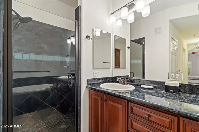 a bathroom with a granite countertop sink a mirror and a shower