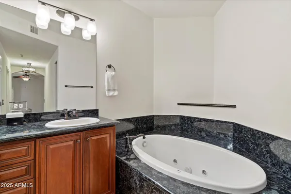a bathroom with a granite countertop sink and a mirror