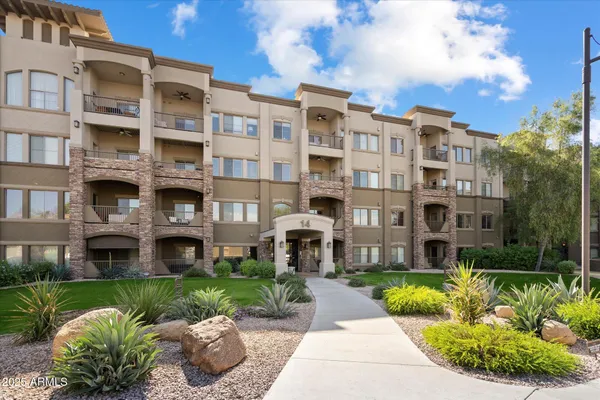 a front view of a building with a garden and plants