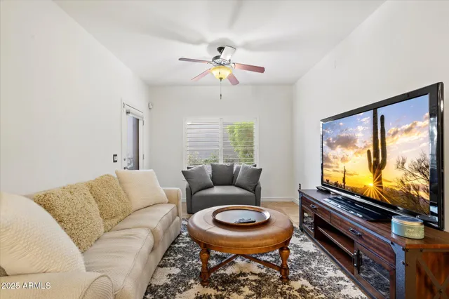 a living room with furniture a flat screen tv and a window