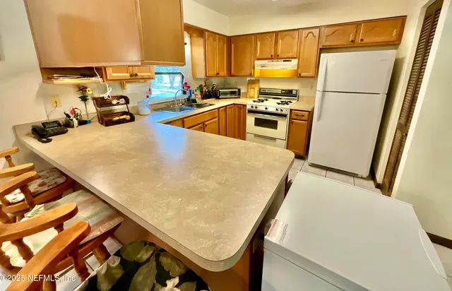 a kitchen with sink refrigerator and stove