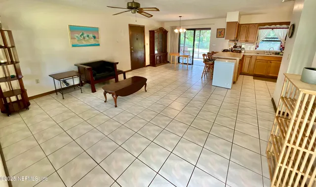 a living room with couches a stove and a dining table with kitchen view