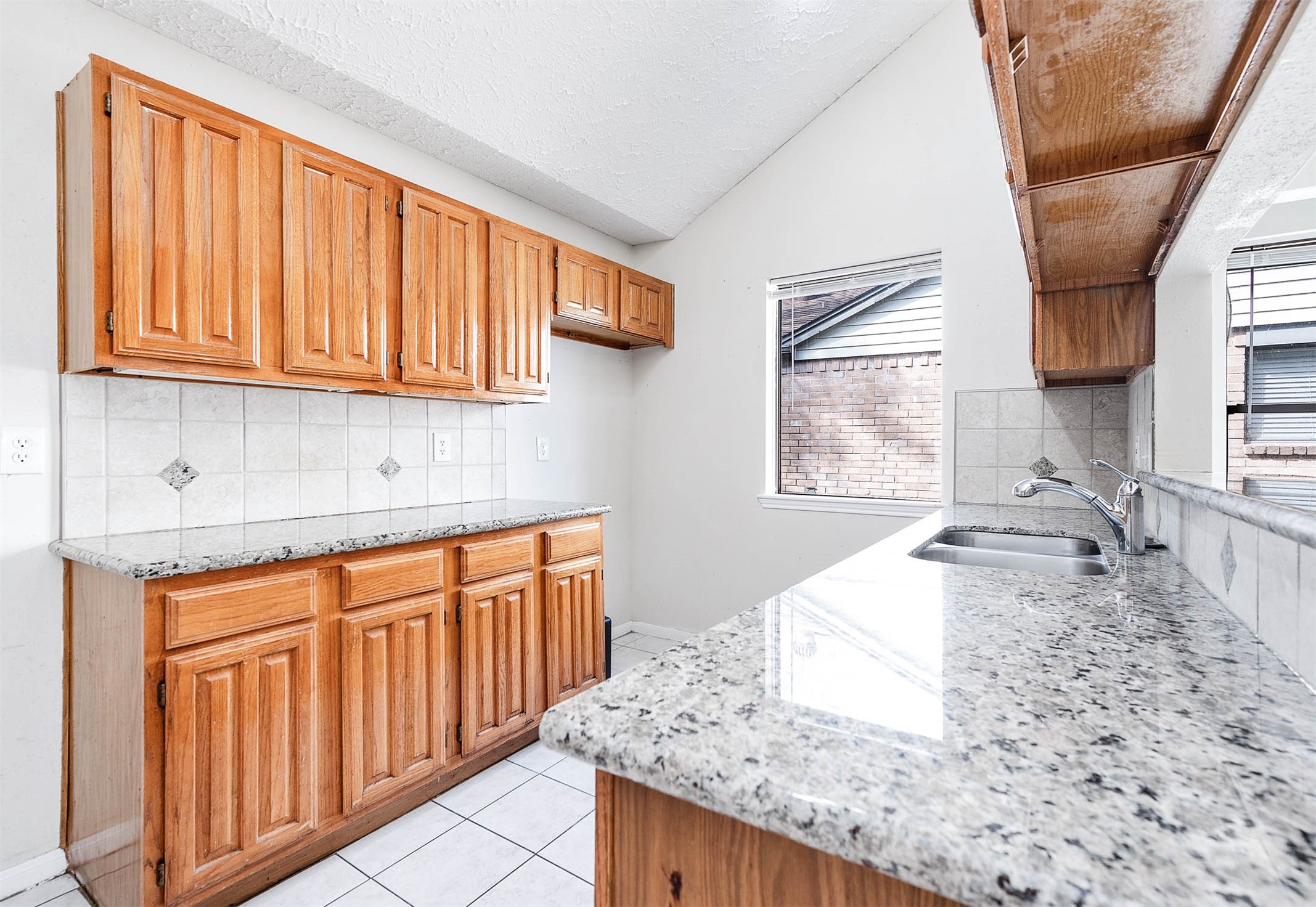 2015 Echo Ridge Sugar Land, TX 77478 - Photo 11 of 29 a kitchen with granite countertop wooden cabinets a sink and dishwasher