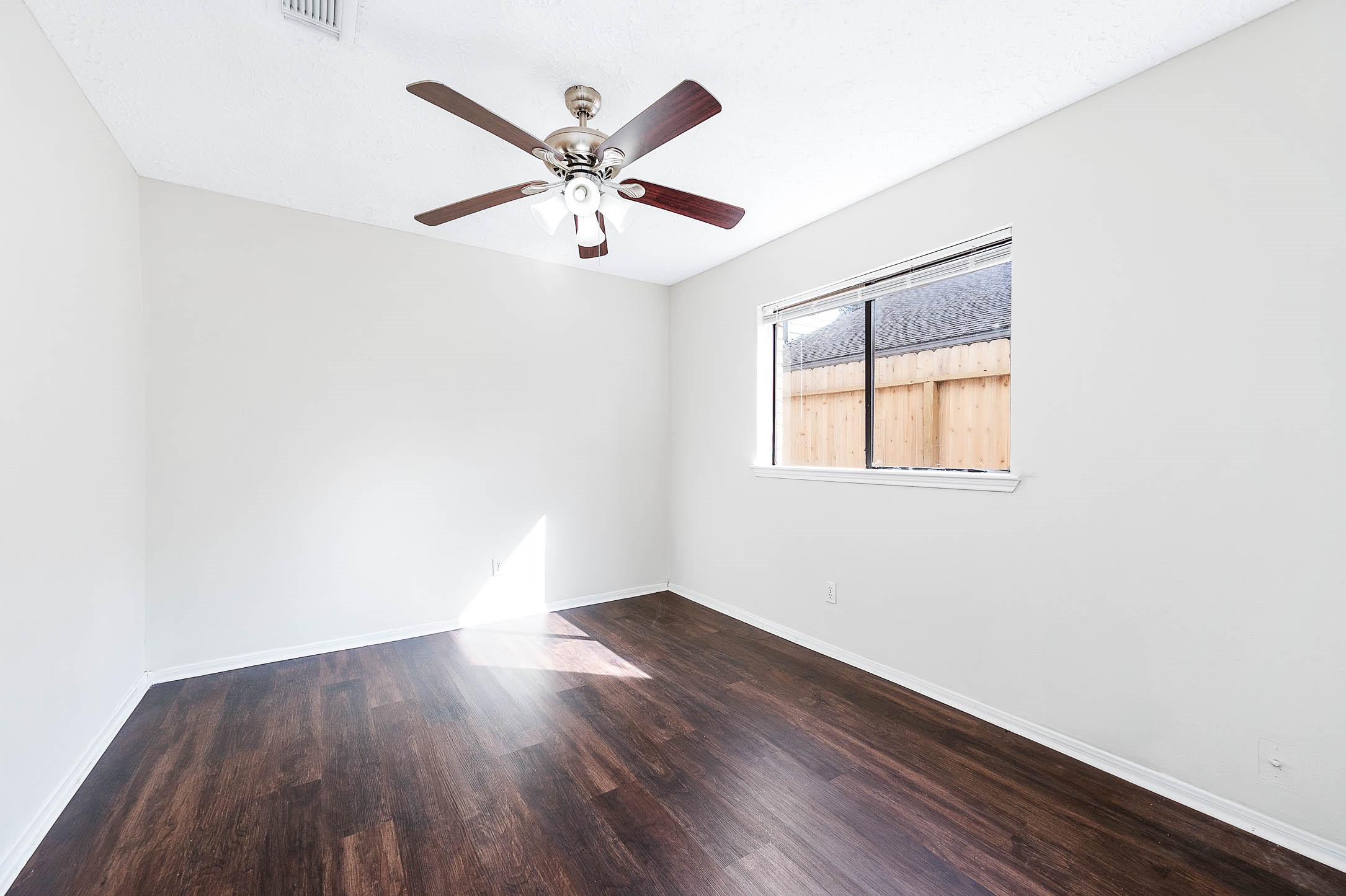2015 Echo Ridge Sugar Land, TX 77478 - Photo 22 of 29 an empty room with wooden floor fan and windows