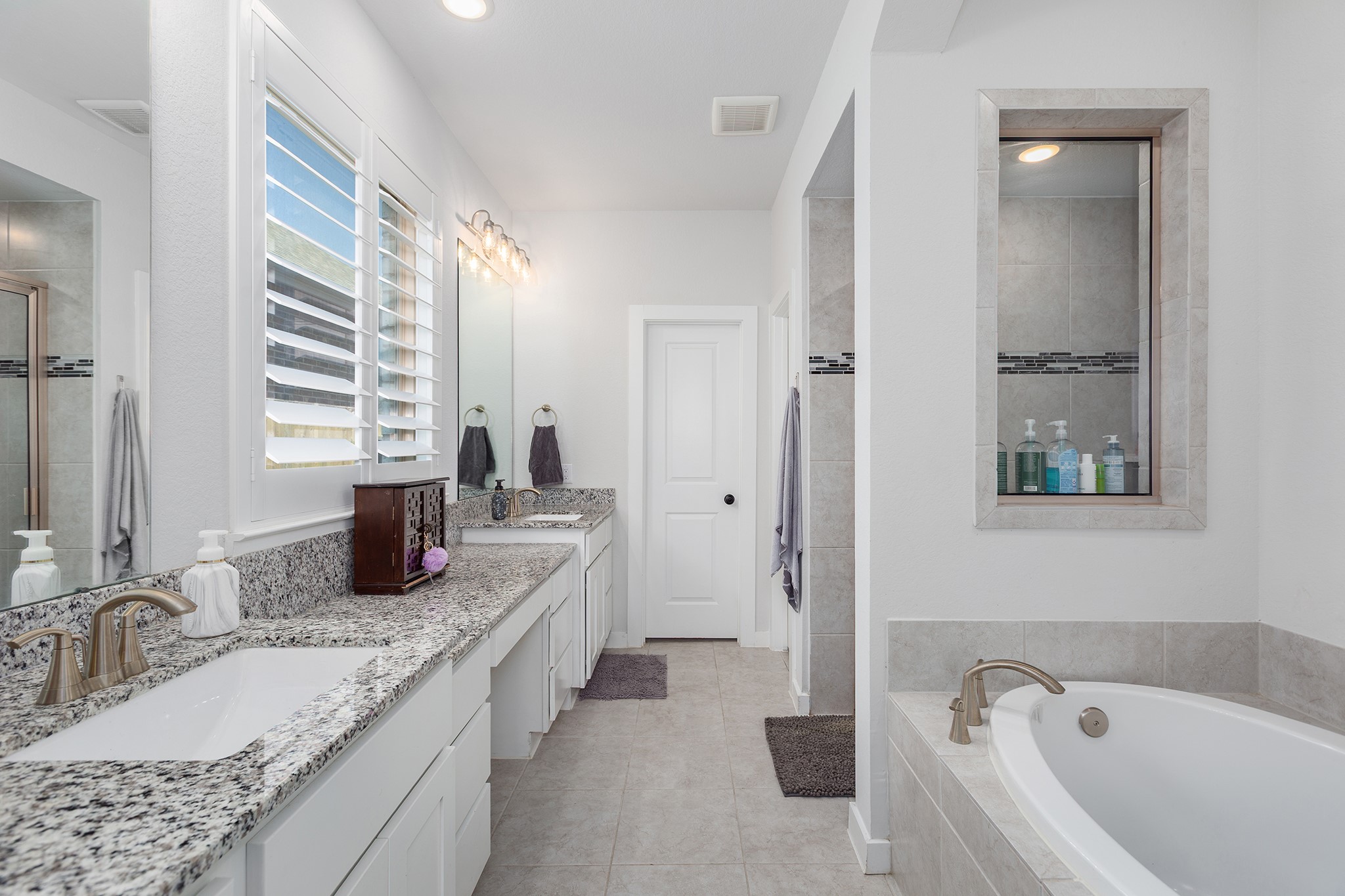 12110 Woodnote Lane Humble, TX 77346 - Photo 20 of 36 a bathroom with a granite countertop tub sink and mirror