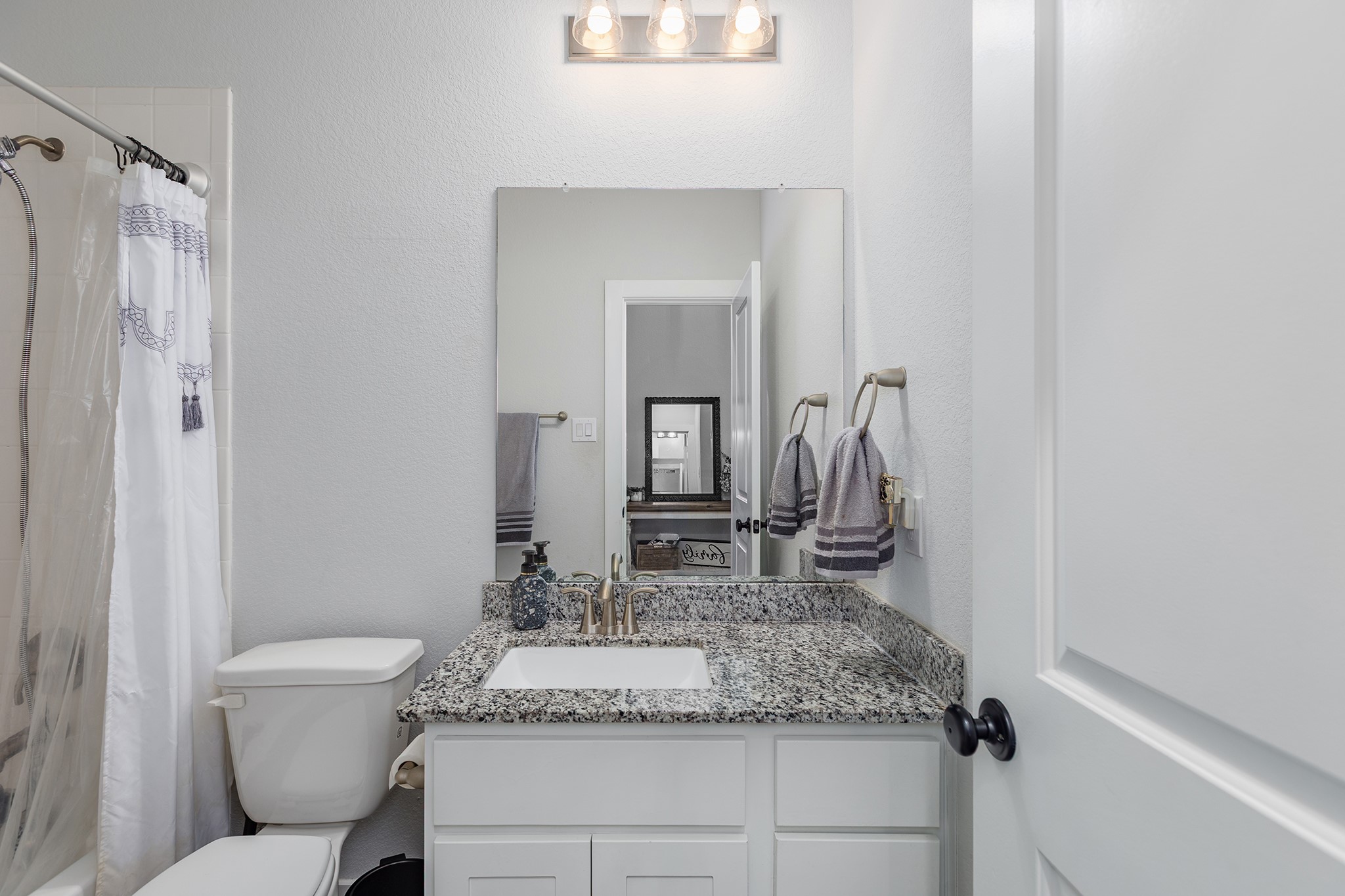 12110 Woodnote Lane Humble, TX 77346 - Photo 24 of 36 a bathroom with a granite countertop sink and a mirror