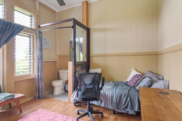 a bedroom with a bed and wooden floor