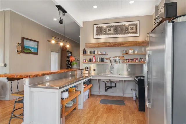 a kitchen with stainless steel appliances granite countertop a sink and a refrigerator