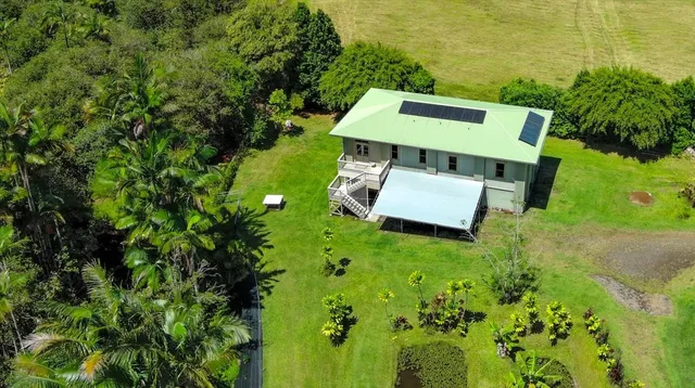 an aerial view of a house with swimming pool and garden