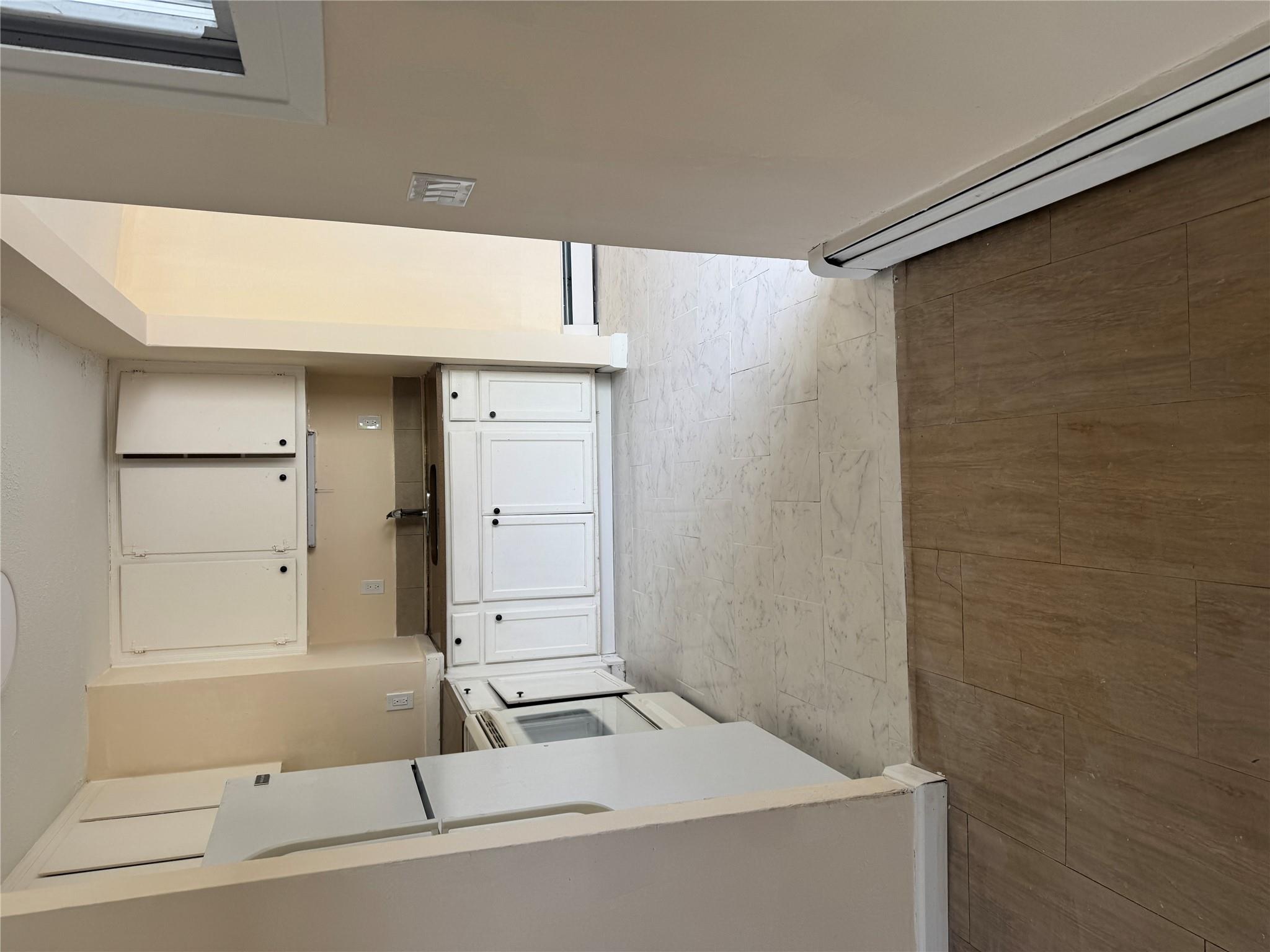 1 Pine Road Middle Island, NY 11953 - Photo 3 of 21 Kitchen featuring a sink, stove, a baseboard heating unit, and white cabinetry