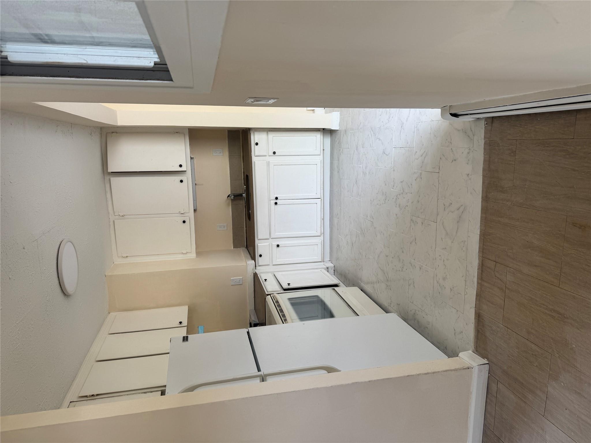 1 Pine Road Middle Island, NY 11953 - Photo 5 of 21 Kitchen with fridge, stove, a baseboard radiator, white cabinetry, and a sink