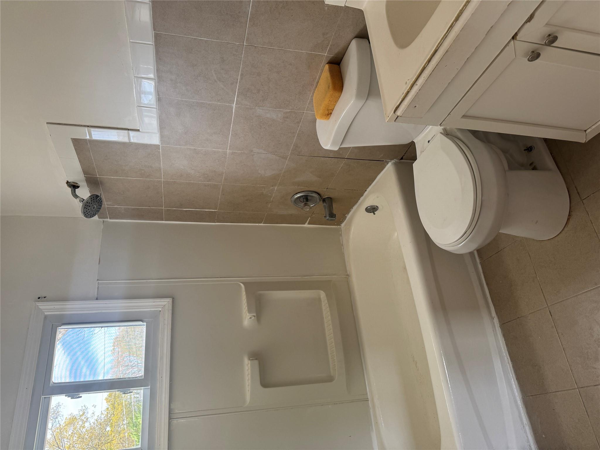 1 Pine Road Middle Island, NY 11953 - Photo 10 of 21 Bathroom with tile patterned flooring, vanity, toilet, tile walls, and washtub / shower combination