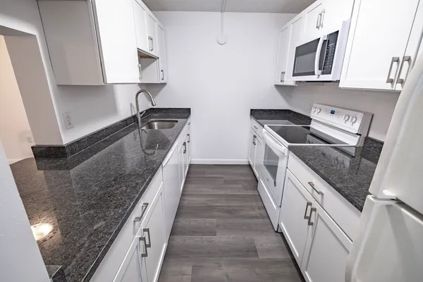 a kitchen with stainless steel appliances granite countertop a sink and a stove