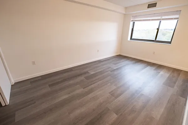 a view of empty room with wooden floor