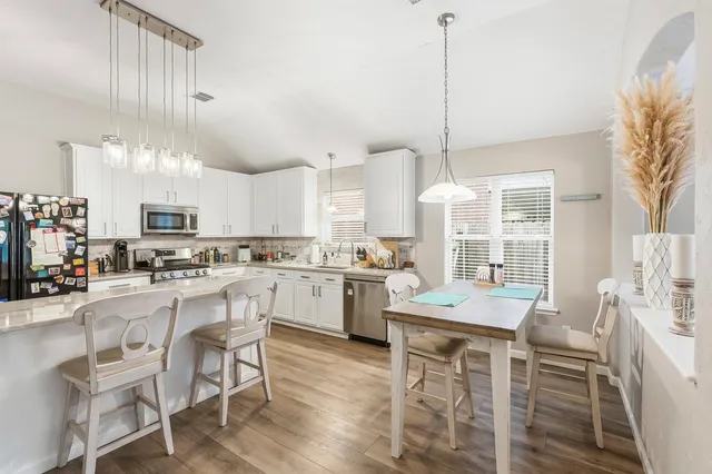 a kitchen with appliances a sink a counter top space and cabinets