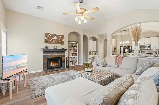 a living room with furniture a fireplace and a flat screen tv