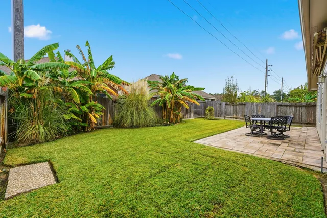 a view of a backyard with table and chairs and wooden fence
